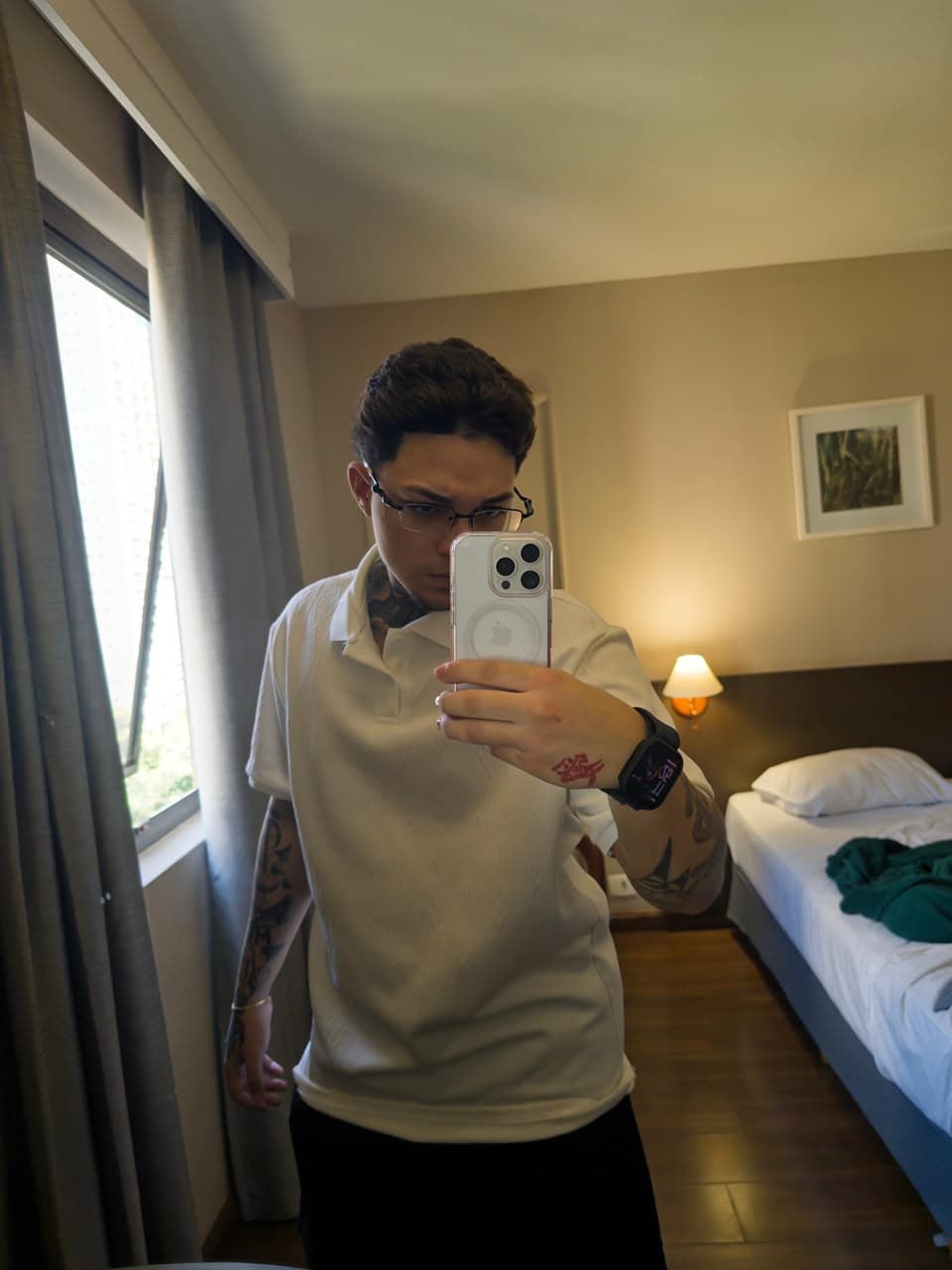 Marinho em frente ao espelho, usando camisa branca e óculos